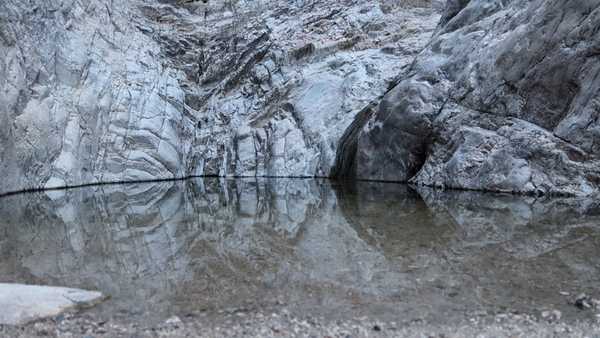 A shallow pool where the slow trickling waterfall empties at the end of the Waterfall Trail