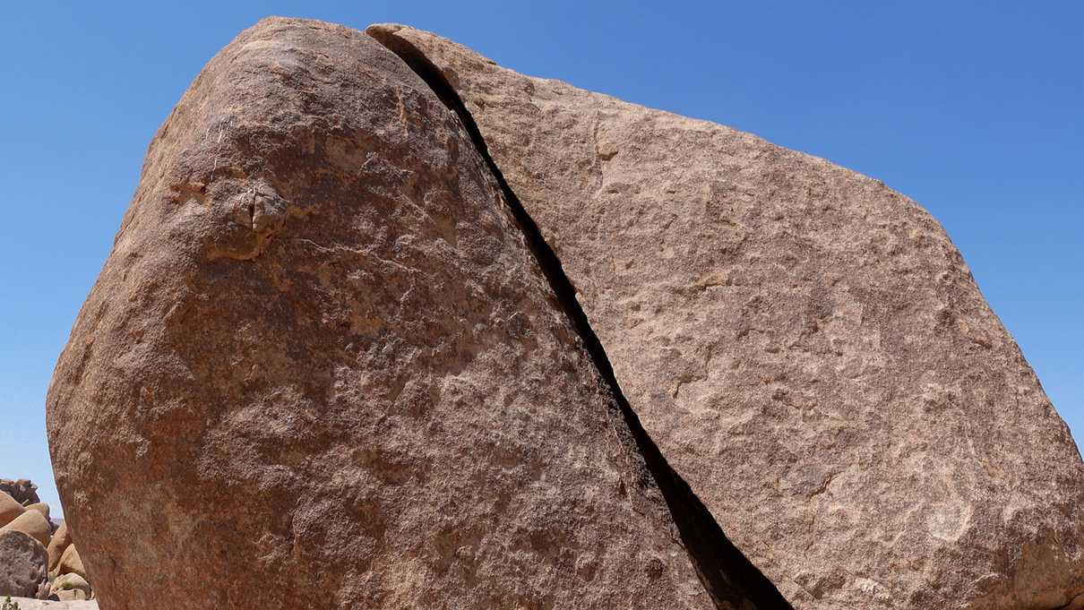 Red toned boulder with curved split in it