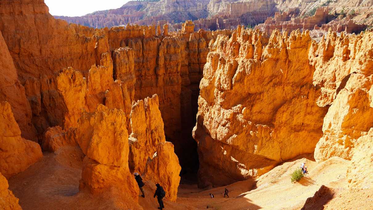 View from the top of rising switchbacks of trail through red canyon walls