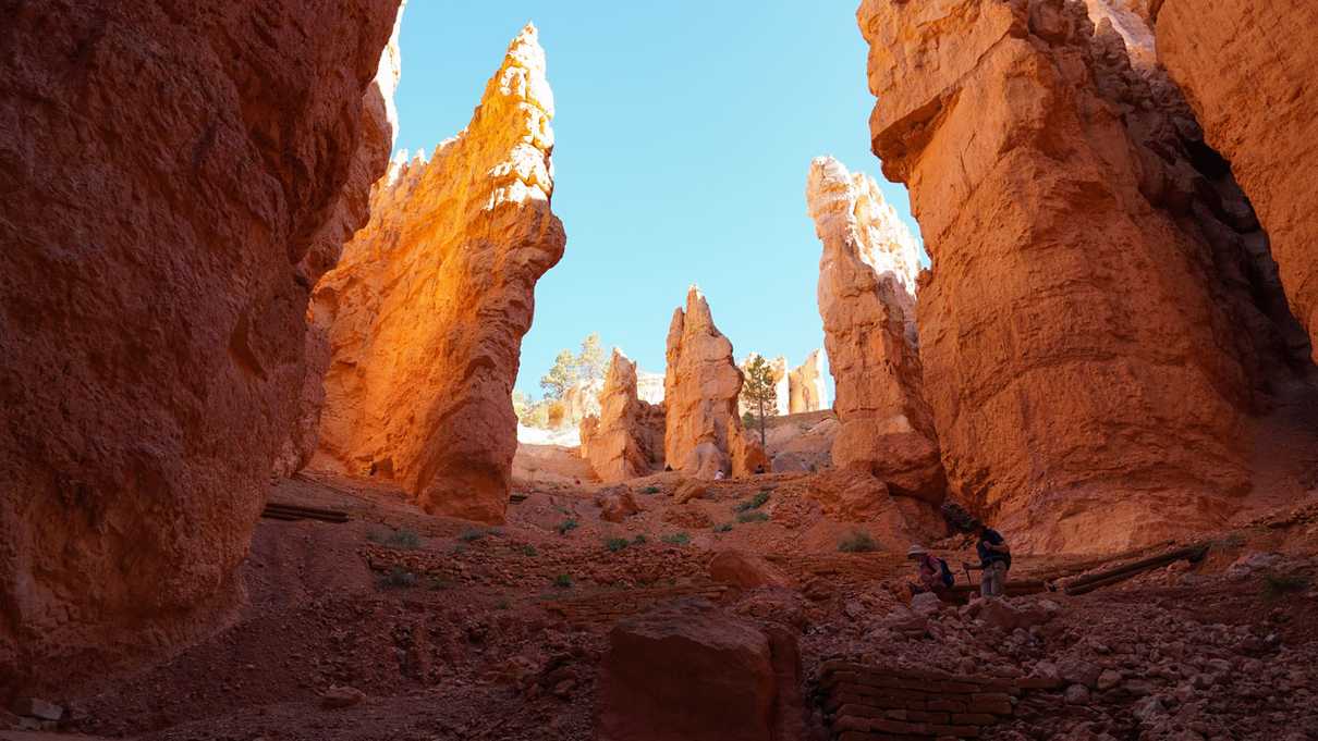 View from the bottom of rising switchbacks of trail through red canyon walls