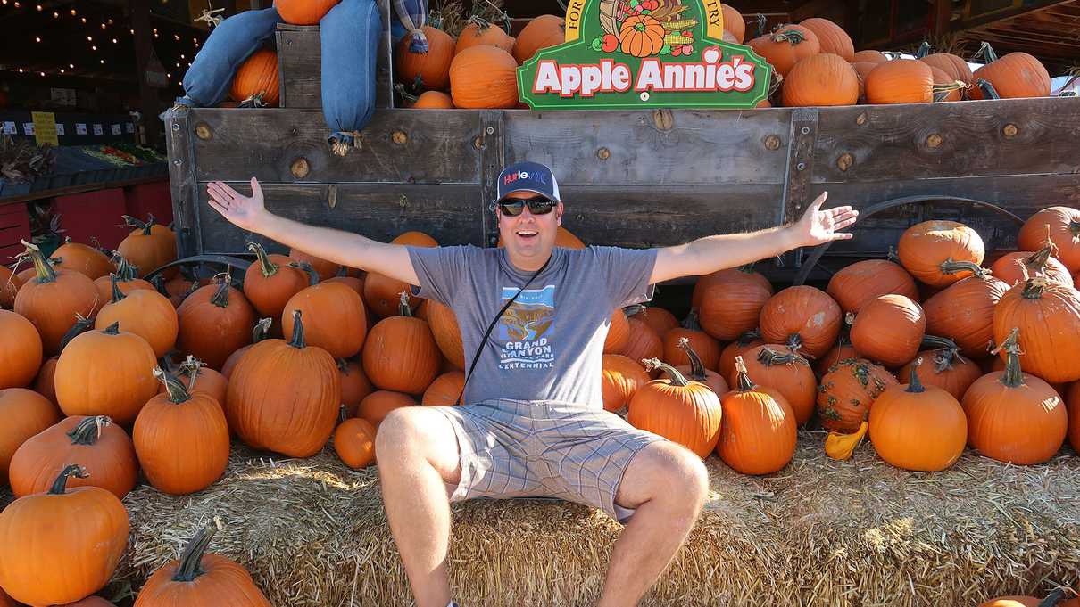 Sitting by a pile of pumpkins