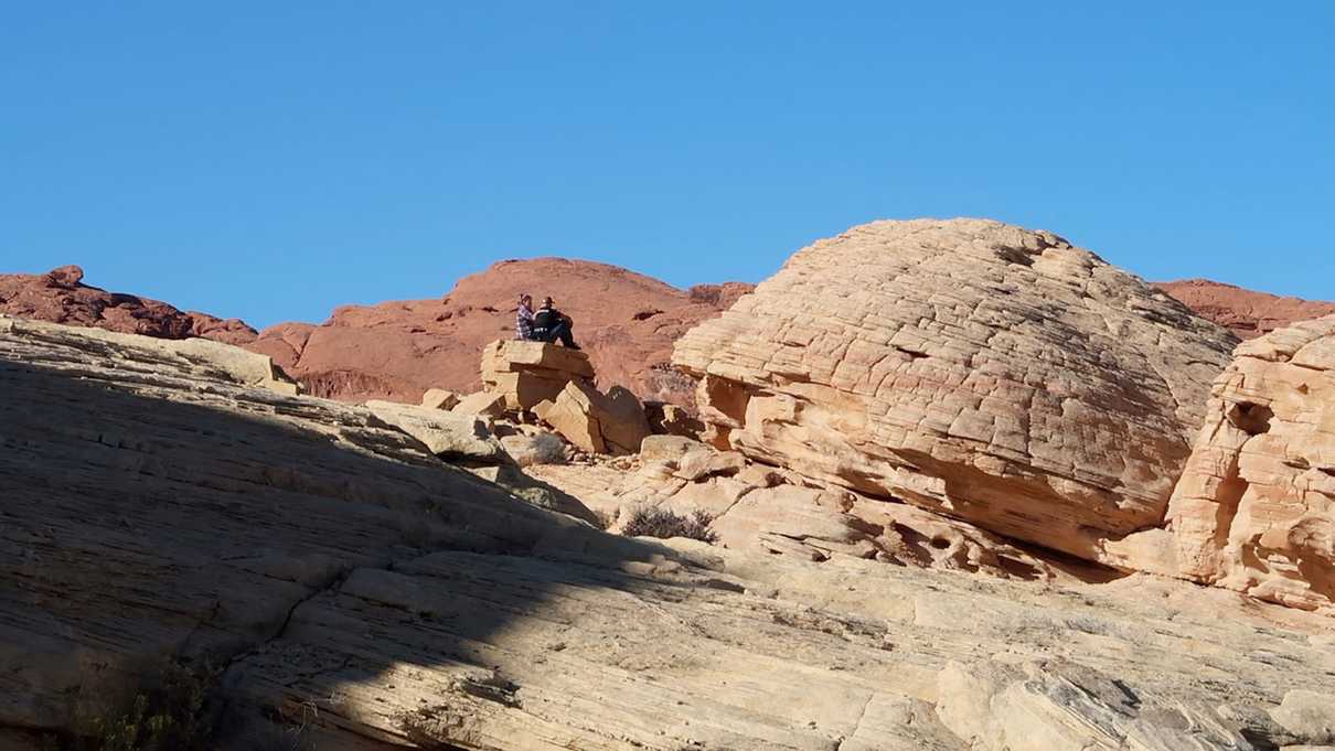 A couple sitting, enjoying the view behind Parking Lot #1 at Valley of Fire State Park
