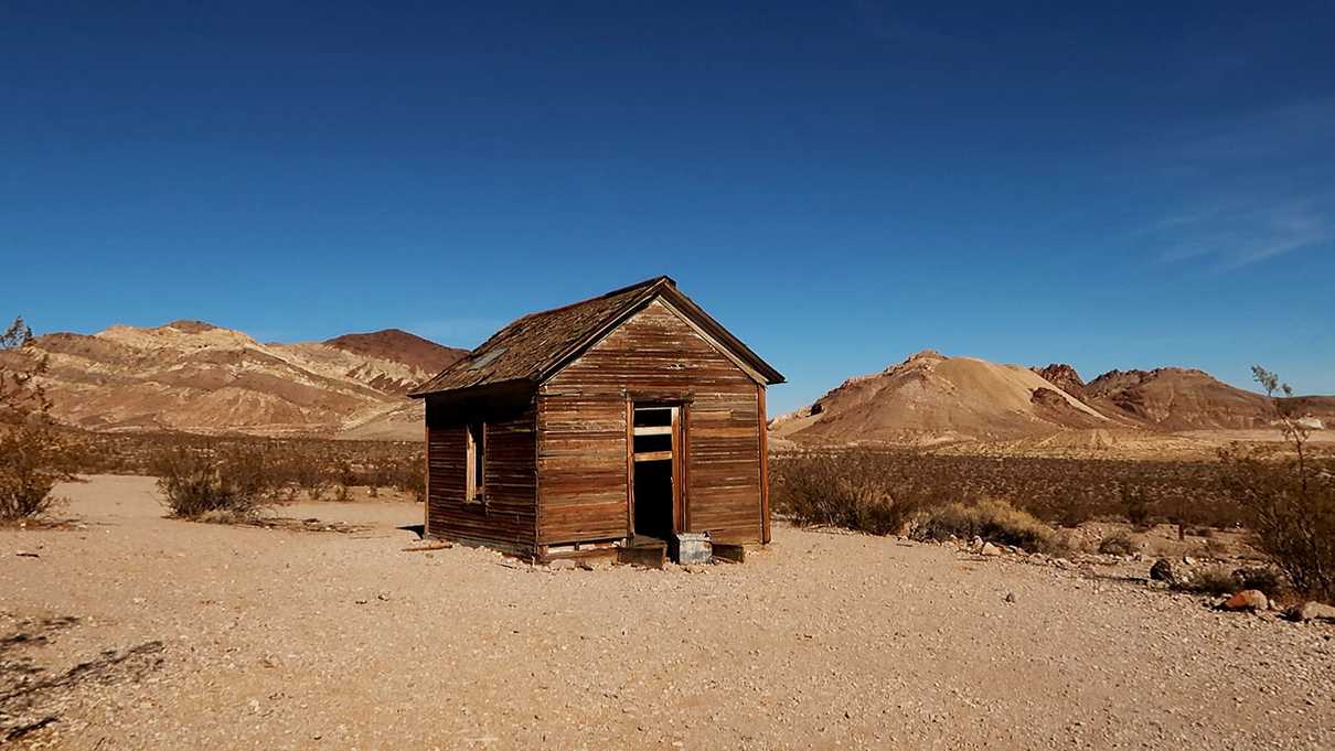 Old wooden house sits alone in dry desert