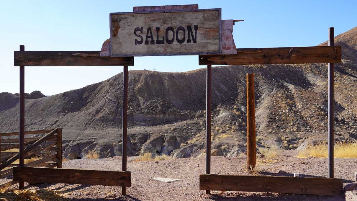 Remaining wood framework of building and sign which says Saloon