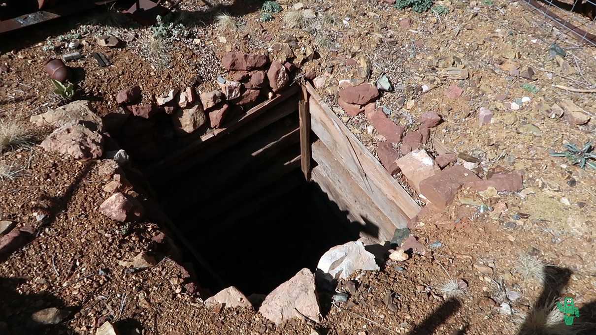Mine shaft in ground with wooden supports for walls