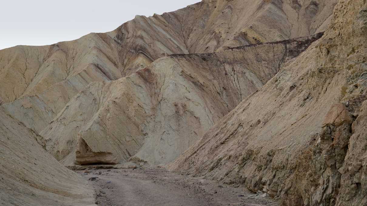 Dirt trail leading through golden canyon walls