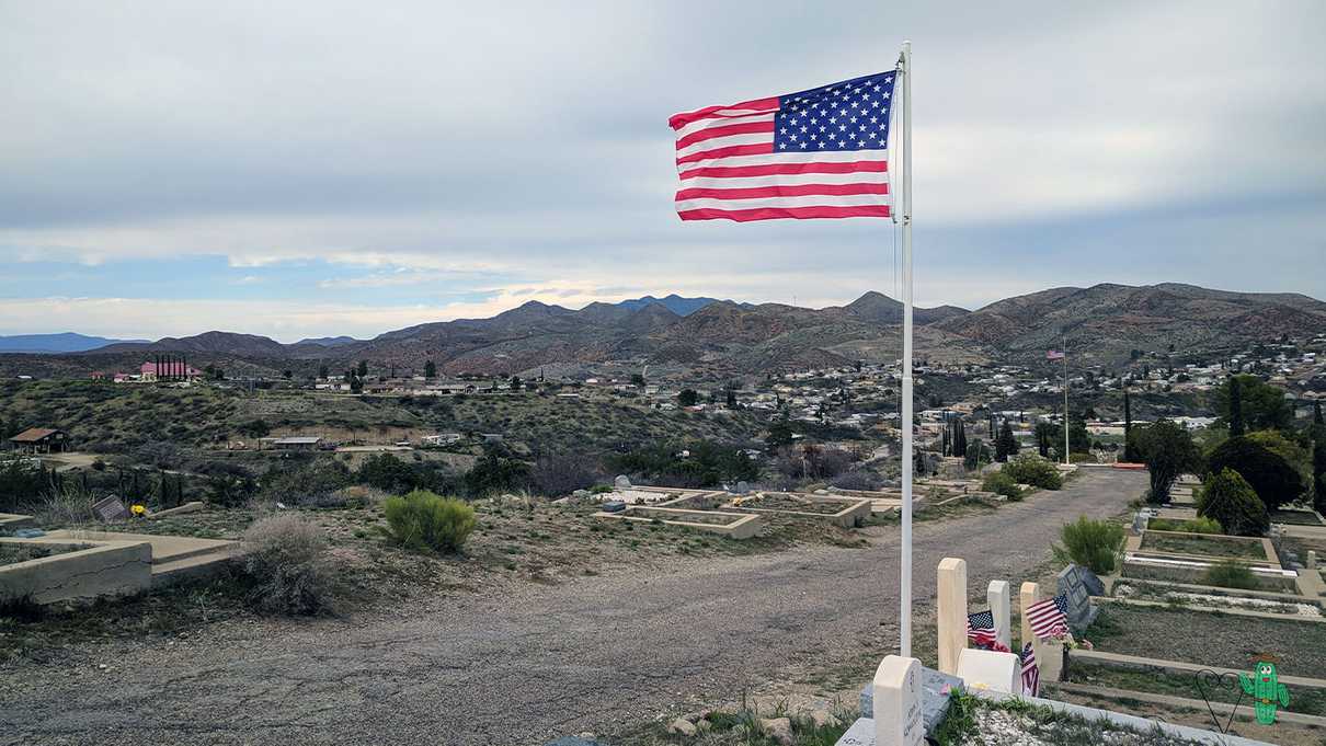 American flag and graves cover hillside of cemetery