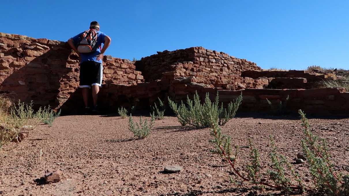 Male figure looking at rock wall ruins