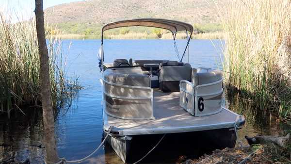 A pontoon boat docked at one of the boat-in campsites