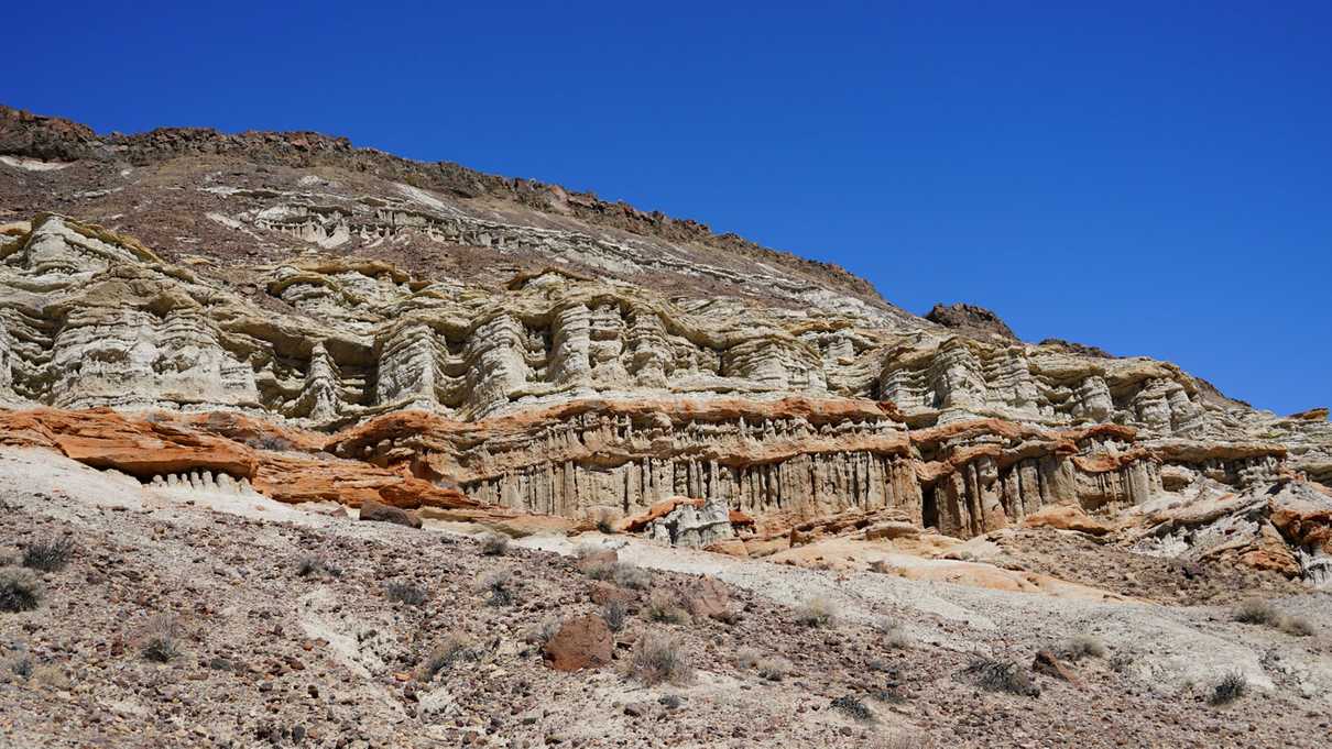 Wall of layered red and grey rock formations