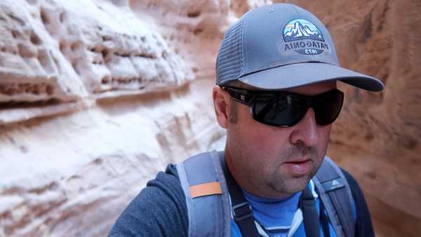 Hiker passing through a slot canyon on the White Domes Loop Trail