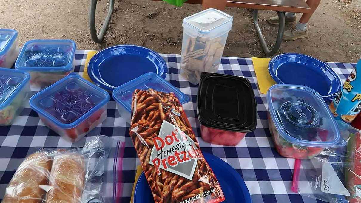 Picnic table filled with containers of food