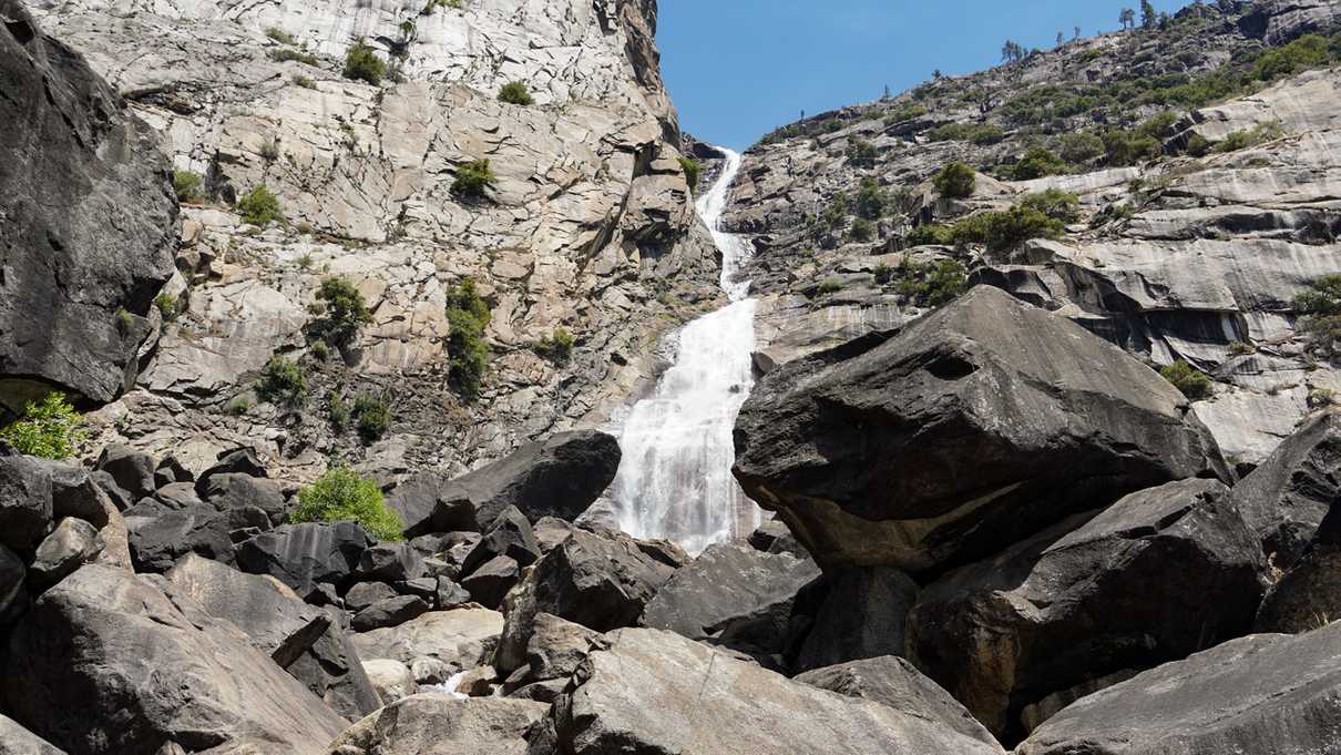 Water cascading down wall of grey rock