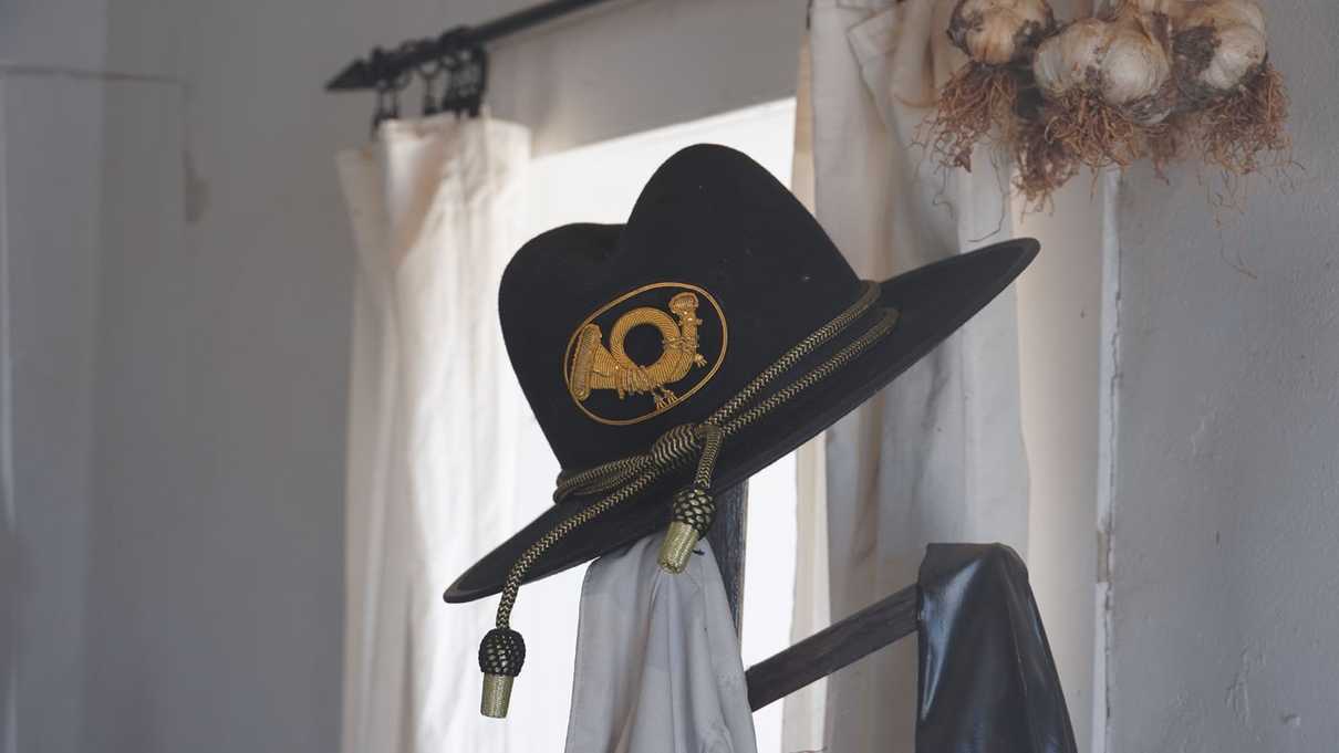 Army hat placed on bedpost of metal frame