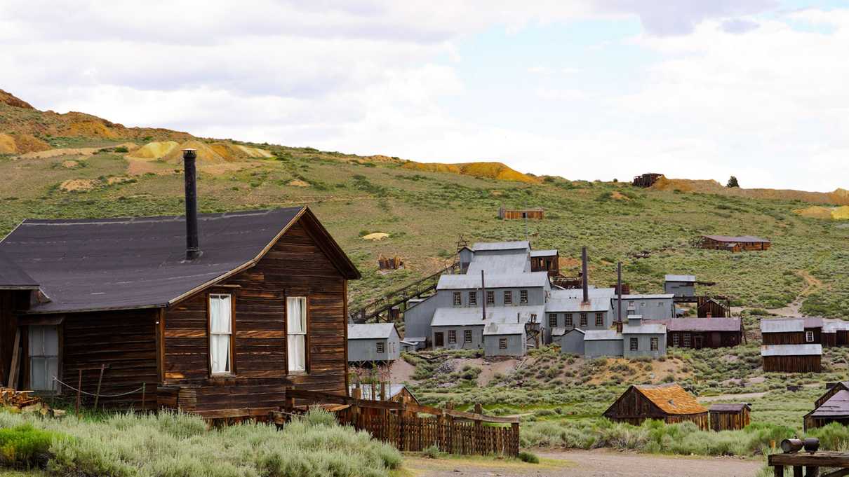 Remnants of an old mill and wooden buildings dot hillside