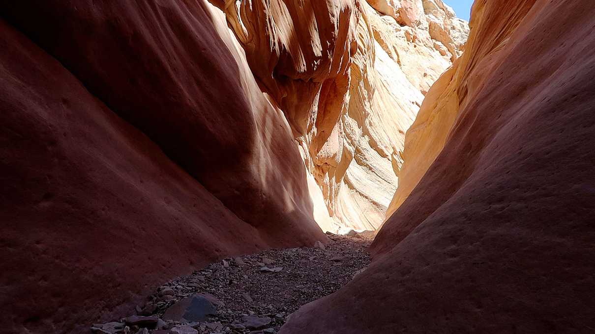 Sunlight at the end of dimly lit slot canyon
