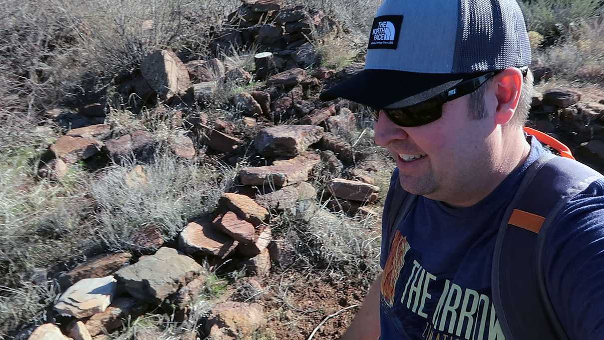 Smiling man amongst low rock walls