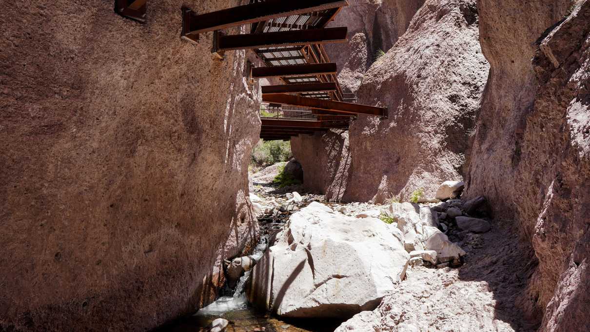 Looking up at steel walkway with water flowing underneath