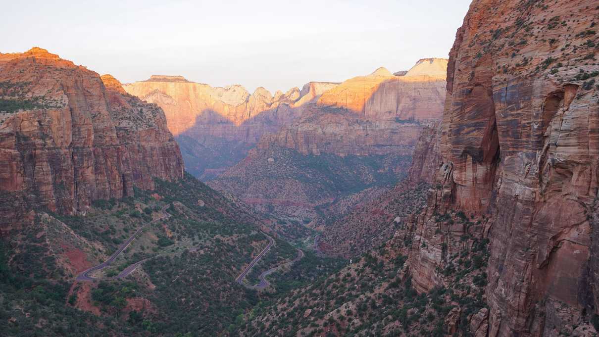 A road winds back and forth through the bottom of a valley