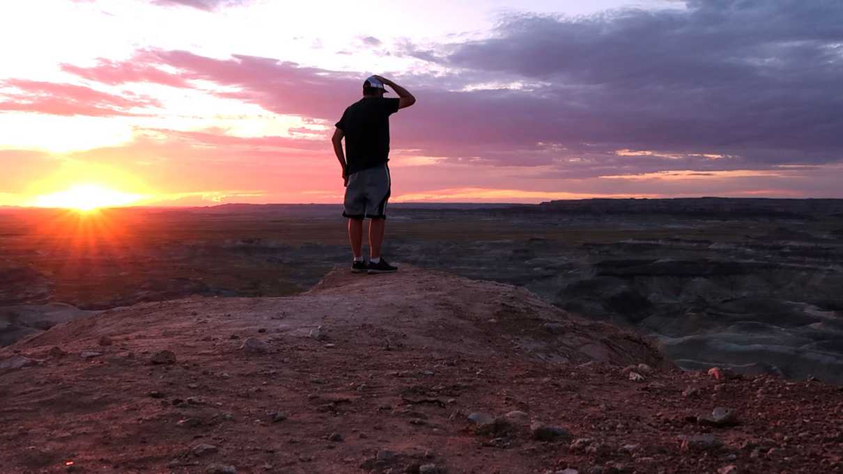 Male figure facing setting sun