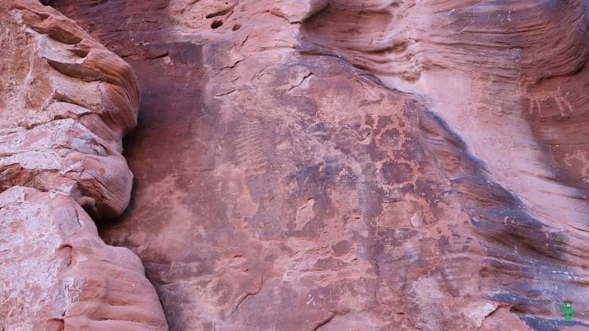 Faint petroglyphs on sandstone near the tank
