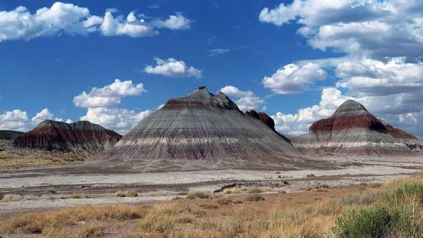 Striped hills and clouds against a blue sky